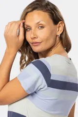 Remera de manga corta con rayas horizontales en tonos celeste, azul y gris. Presenta cuello redondo con abertura de botones.