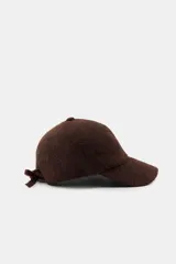 Gorra con visera confeccionada en tejido de punto con textura suave y acabado afelpado.