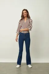 Jean de denim azul de corte flare, con tiro medio, diseño de botamanga acampanada y sutil estampado texturizado en toda la prenda.