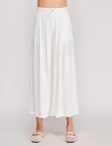Pantalón palazzo de lino y viscosa, color blanco, de tiro alto y silueta amplia. Presenta pinzas frontales, bolsillos laterales y cierre con botón.
