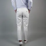 Pantalón de gabardina color azul marino, de corte ajustado y tiro medio, con cierre y botón frontal.