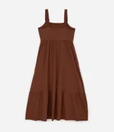 Vestido midi de algodón color marrón, con escote cuadrado y breteles anchos con detalle de volados. Presenta un corte imperio con elástico en la cintura y falda con recortes y volados en el ruedo.