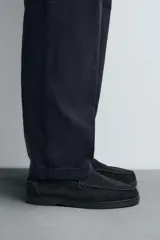 Mocasín casual de hombre con parte superior de piel con acabado serraje, diseño de corte liso con detalle de bordón, horma redonda y suela a tono.