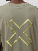 Camiseta de corte oversize color verde oliva, confeccionada en algodón orgánico. Presenta un diseño gráfico de una cruz grande bordada en color amarillo neón en la espalda.