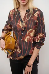 Camisa de manga larga con estampado floral en tonos marrones y negros, cuello mao y cierre frontal parcial con botones.