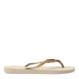 Sandalias tipo ojotas Havaianas modelo Slim Glitter II, color beige arena, con tiras finas cubiertas de glitter dorado.