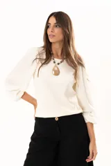 Blusa de cuello redondo con mangas largas tipo globo y puños elásticos. Presenta un diseño de textura combinada en el frente y las mangas.