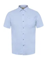 Camisa de lino orgánico color celeste de manga corta, con cuello camisero, cierre frontal de botones, bolsillo en el pecho con logo bordado y calce regular.