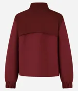 Campera deportiva femenina, modelo rompevientos, confeccionada en poliamida, con cuello alto y puños ajustados. Sin estampa, tiene cierre delantero con cremallera y recortes con hilo reflectante.