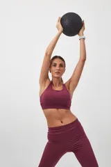 Top deportivo color borgoña con espalda cruzada de cuatro tiras y almohadillas removibles.