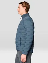 Campera técnica acolchada de plumón, color azul, con cierre frontal de dos vías, cuello alto, bolsillo en el pecho con cierre y bolsillos laterales. Presenta una construcción elástica tejida que permite mayor libertad de movimiento.