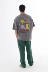 Remera gris con efecto acid wash, corte oversize y estampa en la espalda con personajes de dibujos animados (Bob Esponja, Itchy, Peppa Pig y Bart Simpson) con fajos de billetes.