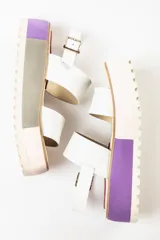 Sandalias negras de cuero con plataforma blanca y hebilla metálica.