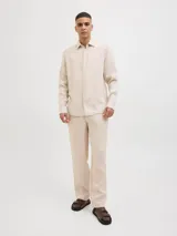 Pantalón chino de lino color beige, corte clásico, con cierre de cremallera y cintura con elástico.