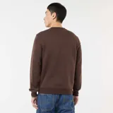 Buzo liso marrón de cuello redondo, con detalles de costura en V en el cuello y puños y dobladillo acanalados.