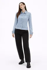 Campera de jean en tono celeste claro, con diseño de frunces en la parte superior delantera, mangas largas con puños ajustados y cierre frontal mediante botones metálicos.