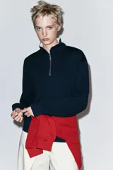 Sudadera roja de cuello alto con cierre frontal de cremallera y diseño de manga larga, con interior en tono contrastante.