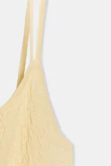 Vestido largo color amarillo pálido, de breteles finos cruzados en la espalda y falda plisada.