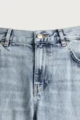 Jeans flare fit de tiro medio, confeccionados en denim de algodón color azul con efecto deslavado. Diseño ajustado en la parte superior y abierto en campana desde la rodilla, con cinco bolsillos y cierre frontal con cremallera y botón.