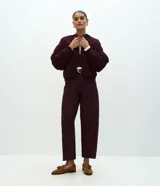 Pantalón modelo carrot de sarga, con cintura alta, pretina con presillas, cierre frontal con botón y cremallera, y bolsillos funcionales. Presenta un calce holgado en la cadera que se estrecha hacia el bajo.