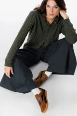 Zapatillas urbanas de cuero con diseño bicolor en tonos camel y negro, con cordones jaspeados y suela de goma color caramelo.