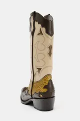 Bota estilo cowboy de caña alta, confeccionada en una combinación de cuero marrón oscuro, beige y texturizado efecto piel de serpiente en tonos mostaza. Presenta bordados decorativos, tacón medio en bloque y puntera perfilada.