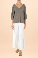 Suéter de punto color gris con cuello en V, manga tres cuartos y detalle de costura central vertical. Presenta un diseño de silueta holgada y terminaciones acanaladas en puños y ruedo.