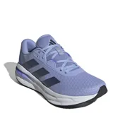 Championes de running Adidas Galaxy 7, color lila con detalles en azul oscuro y suela blanca. Presentan diseño de malla transpirable, mediasuela con tecnología Cloudfoam para mayor amortiguación y cierre con cordones.