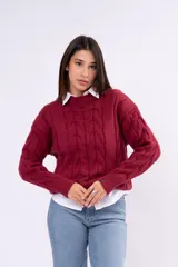 Sweater de tejido de punto con diseño de ochos y trenzas, cuello redondo y mangas largas. Presenta un calce relajado y puños acanalados.