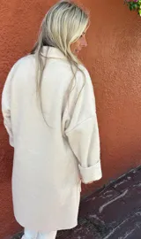 Tapado de corte oversize confeccionado en mezcla de lana y viscosa, color crema. Presenta un diseño desestructurado, liviano, con solapas amplias, bolsillos frontales de parche y mangas largas con puños vueltos.