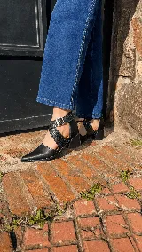 Zapatos de tacón ancho color camel con textura símil serpiente, punta fina y tiras cruzadas con hebilla metálica grande en el lateral.