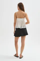 Musculosa blanca de lyocell, con tirantes finos regulables, escote en V y detalle de volados en el delantero, de diseño holgado.