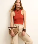 Body color ladrillo, de rib con textura acanalada, cuello alto, sin mangas y corte cavado.