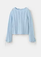 Buzo de punto celeste con diseño recto, detalles calados, cuello redondo y manga larga con cordones ajustables en los puños.