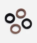 Kit de cuatro gomitas para el pelo texturizadas, en tonos negro y marrón.