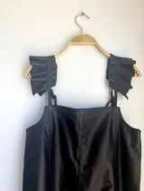 Vestido corto negro de cuero vacuno con breteles finos regulables y corte evasé.