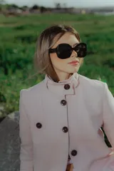 Chaqueta rosa con cuello elevado y cierre frontal con botones marrones.