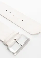 Cinturón ancho de cuero vacuno en color beige, con hebilla metálica rectangular plateada y pasador a juego.