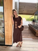 Vestido midi marrón oscuro de corte recto y mangas cortas, con cuello redondo adornado con costuras decorativas y rombos de cuero camel bordados en el frente. Cuenta con aberturas laterales con detalles de costura a contratono.