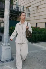 Chaqueta color tostado con cuello solapa, manga larga y cierre frontal con cremallera. Presenta bolsillos delanteros de plastrón con solapa y detalle de cintura ajustable con lazada.