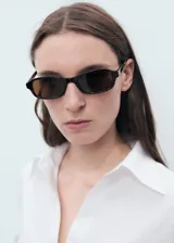 Camisa oversize blanca de lino con cierre de botones frontal, cuello camisero y mangas largas con puños abotonados.