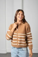 Saco de punto beige con rayas horizontales blancas, cierre frontal completo y cuello redondo.