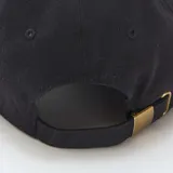 Gorra de béisbol negra con bordado frontal en color blanco que dice 'Casually Iconic'.