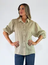 Camisa Amora de lino color beige, con cuello camisero, cierre frontal de botones, mangas abullonadas y puños elásticos.