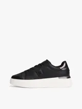 Zapatillas de plataforma Tommy Hilfiger, color negro con suela blanca. Presentan un diseño de corte bajo con cordones, confeccionadas en cuero y material sintético, con el monograma TH en el lateral y detalles metálicos en el talón.