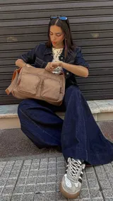 Bandolera de tafeta impermeable color beige, con dos bolsillos frontales con cierre y correa regulable. Diseño práctico y liviano ideal para uso diario.