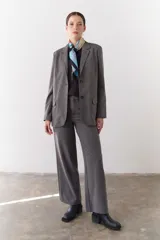 Pantalón marrón de corte recto y pierna ancha, con cintura alta, bolsillos laterales y cierre.