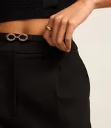 Pantalón recto de cintura alta color negro, confeccionado en punto roma con viscosa sostenible. Incluye trabillas en la cintura, pliegues y cinturón fino de material sintético con hebilla en forma de ocho.