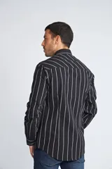 Camisa de manga larga con cuello clásico y cierre frontal abotonado. Presenta un estampado de cuadros en tonos azul marino y rojo. Confeccionada en algodón, cuenta con un corte slim fit y logo bordado en el pecho.