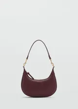 Bolso de hombro tipo hobo en color bordó, con diseño de media luna y acabado efecto piel. Cuenta con cierre de cremallera superior, herrajes metálicos dorados y asa de hombro ajustable y extraíble.